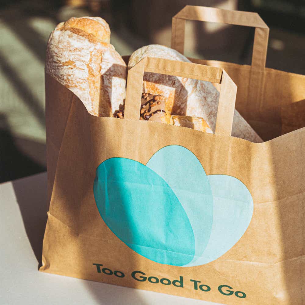 Niespodzianka w uratowanej paczce TooGoodToGo Osoba otwiera torbę odsłaniając świeże owoce i warzywa z aplikacji