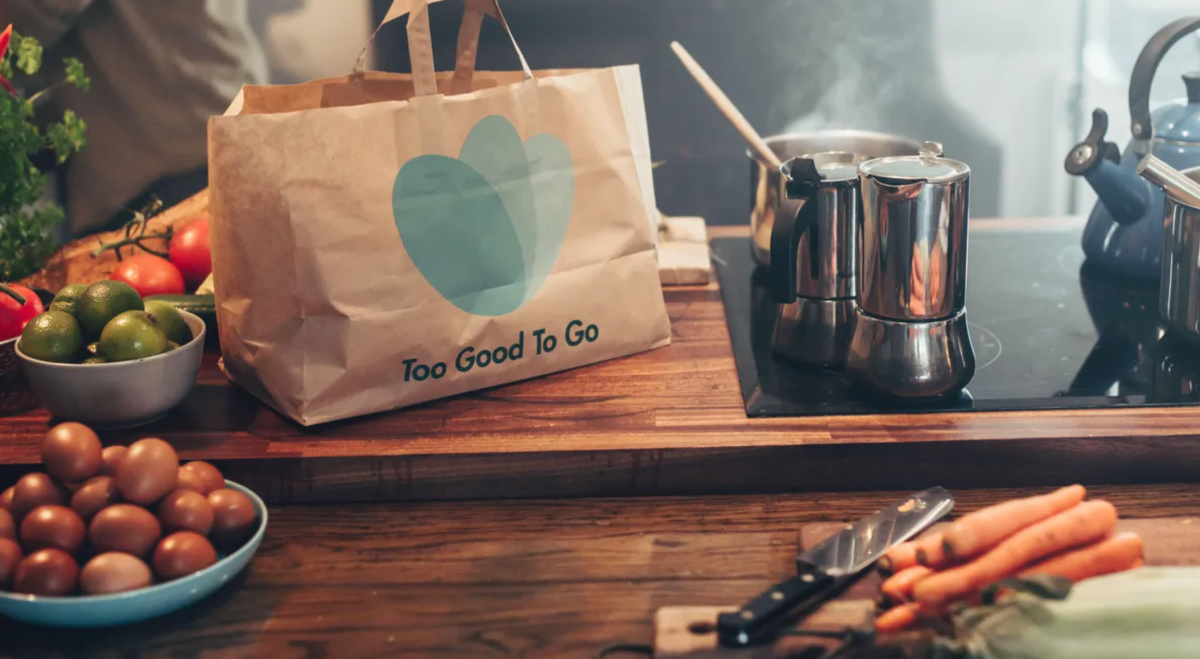 Mapa pobliskich ofert w TooGoodToGo Palec użytkownika klika mapę sklepów w aplikacji Too Good To Go