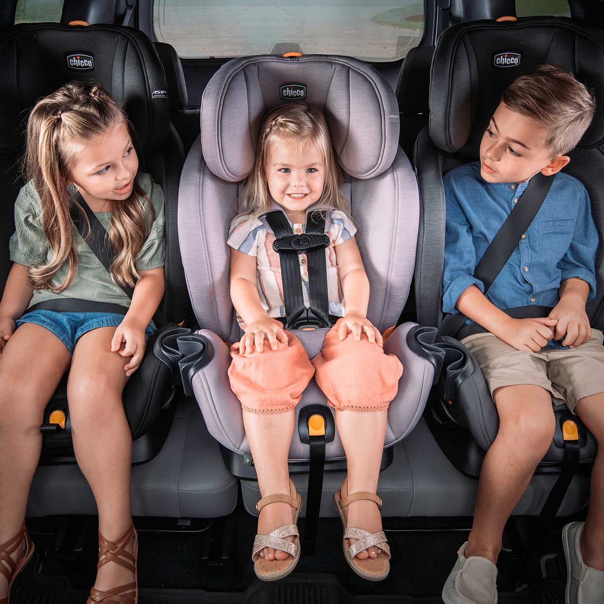 Porównanie trzech modeli fotelików różnych marek obok siebie na stole