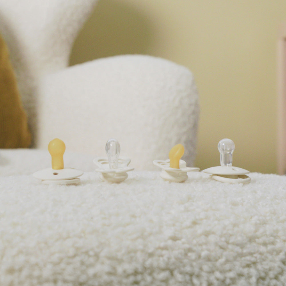 dziecko ssące brązowy smoczek kauczukowy na łące wśród kwiatów polnych