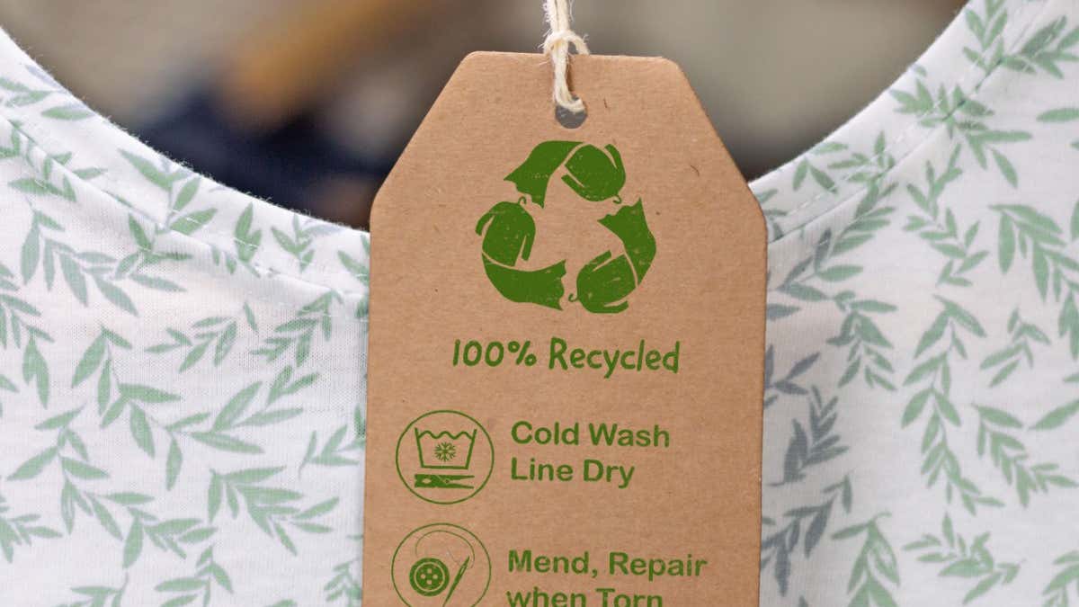 Fabryczna linia produkcyjna z metkami eko na stosie gotowych T-shirtów