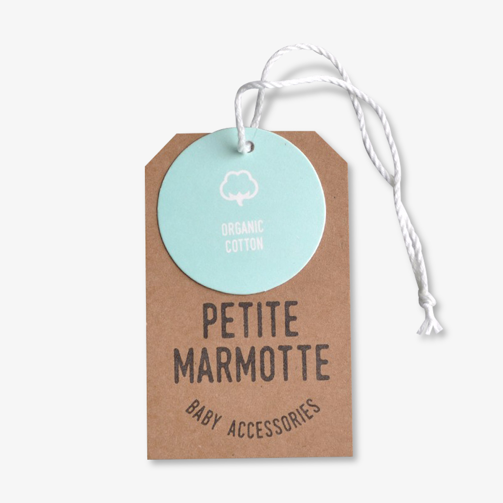 Metka GOTS z ikoną liścia na lnianej koszuli wiszącej na wieszaku sklepowym