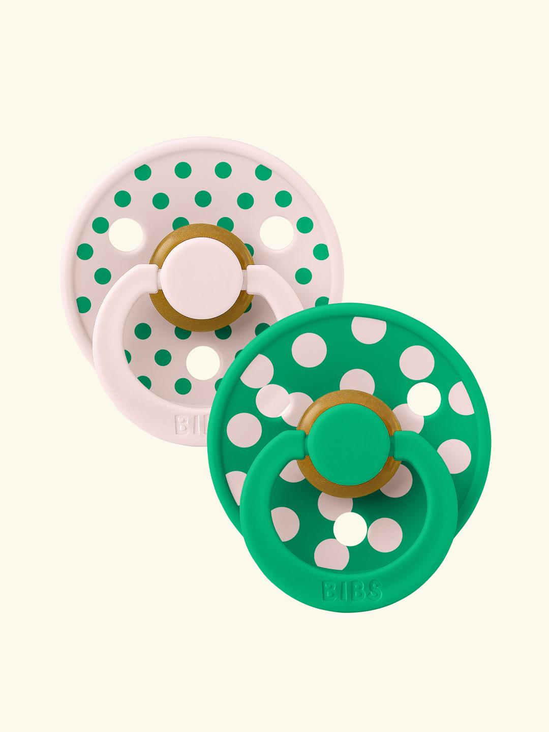 przezroczysty silikonowy smoczek obok kropli ropy naftowej na czarnym tle