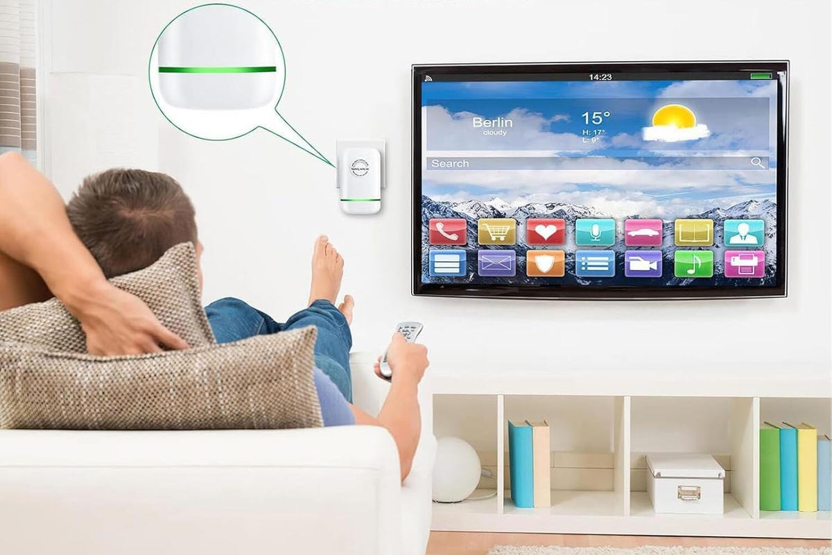 inteligentne gniazdko w ścianie z podłączoną ładowarką i aplikacją na smartfonie pokazującą zużycie prądu