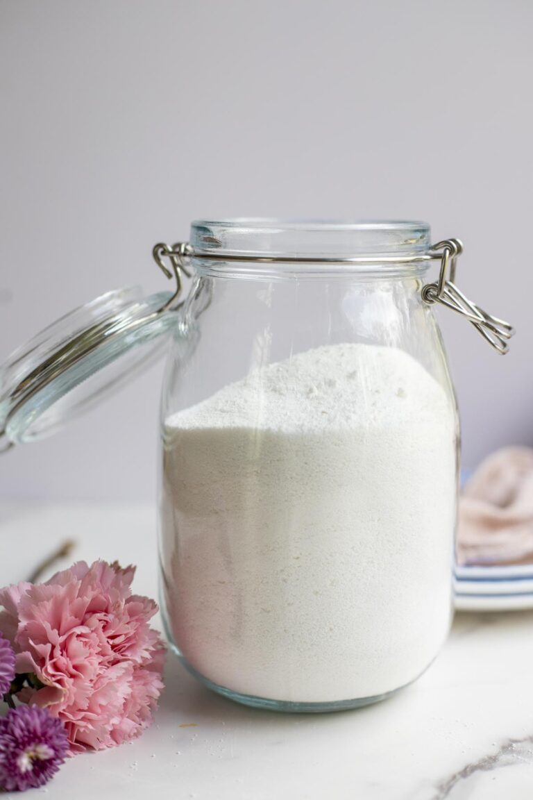 biała soda oczyszczona wsypana do metalowej miski na drewnianym blacie